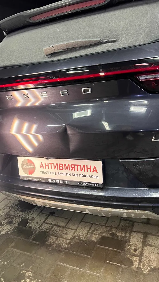 Вмятина на крышке багажника тёмного кроссовера — до ремонта
